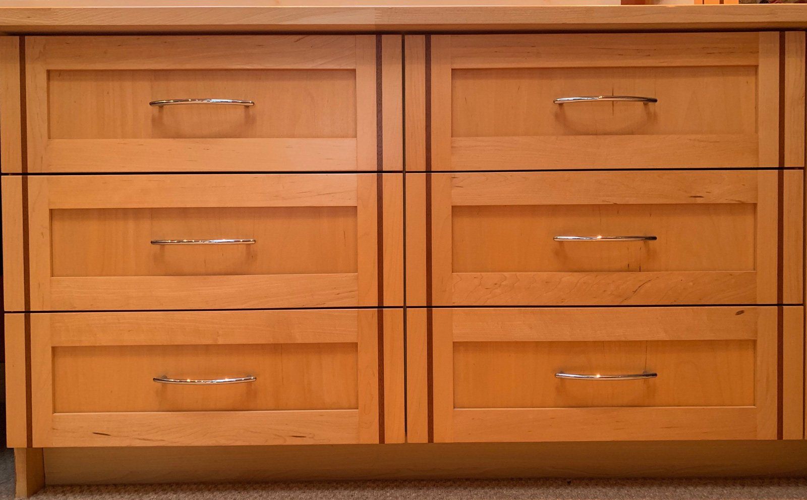 A wooden dresser with six drawers and metal handles