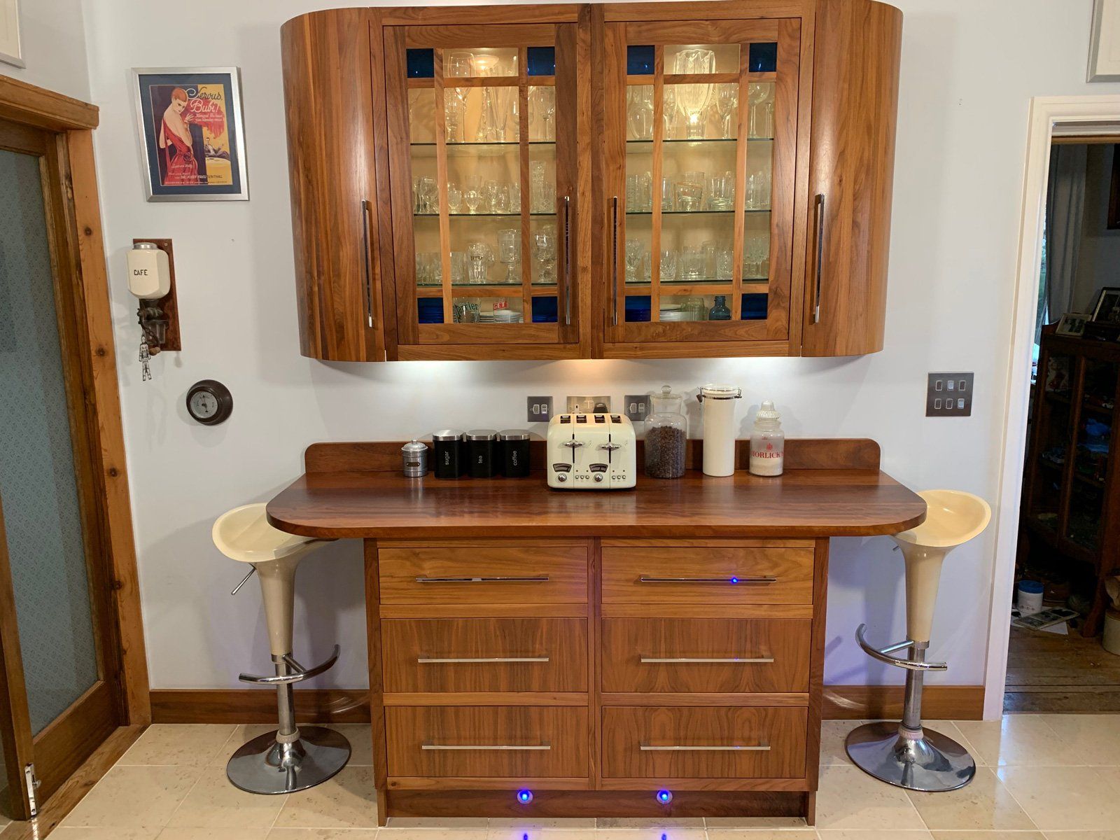 A kitchen with wooden cabinets and stools and a counter top.