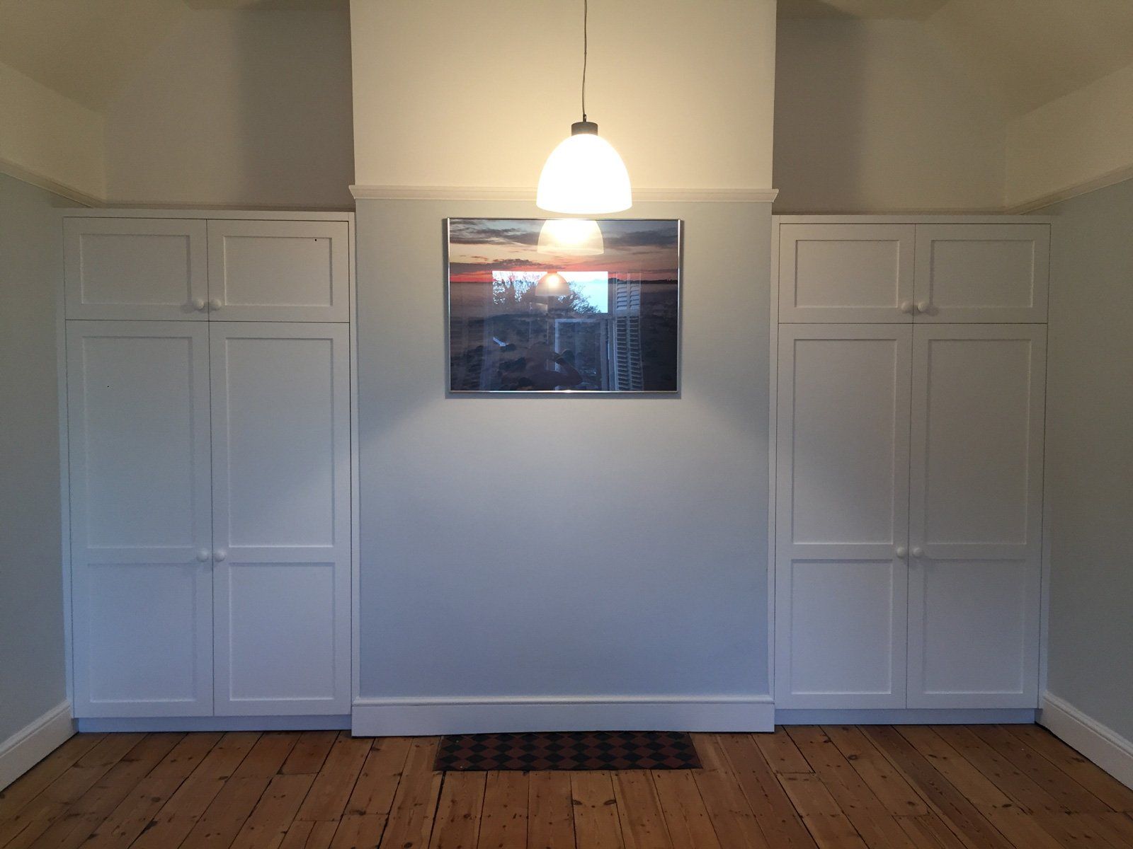 A room with white cabinets and a picture on the wall