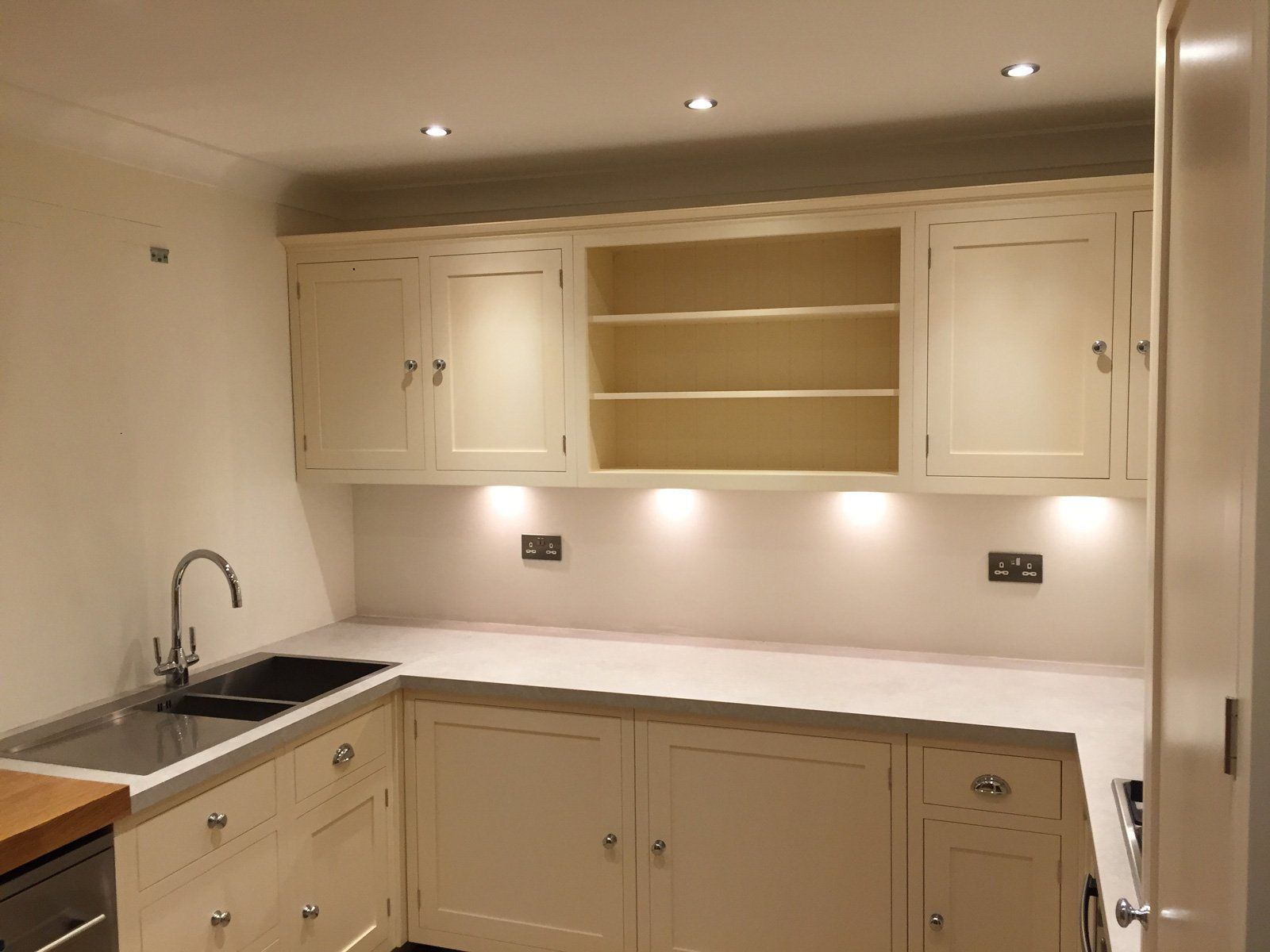 A kitchen with white cabinets , a sink , and a dishwasher.