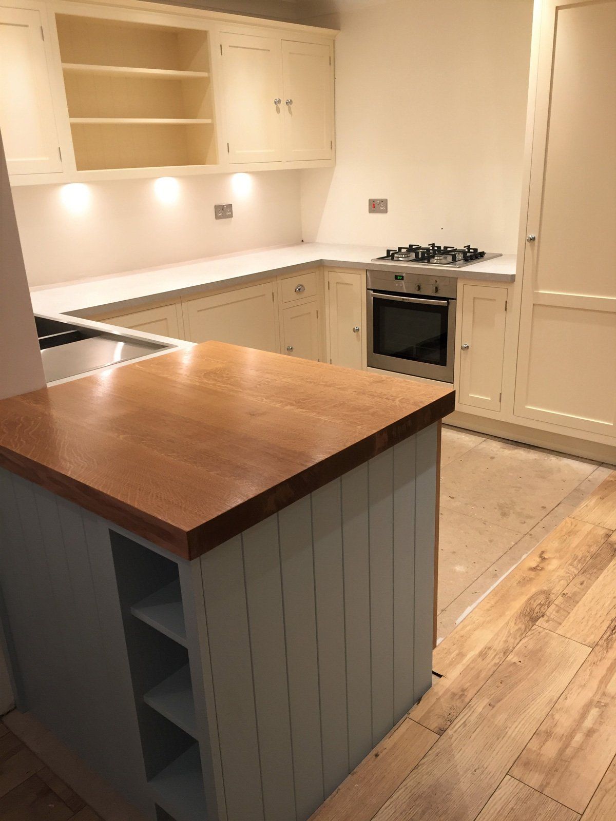 A kitchen with white cabinets and a wooden counter top