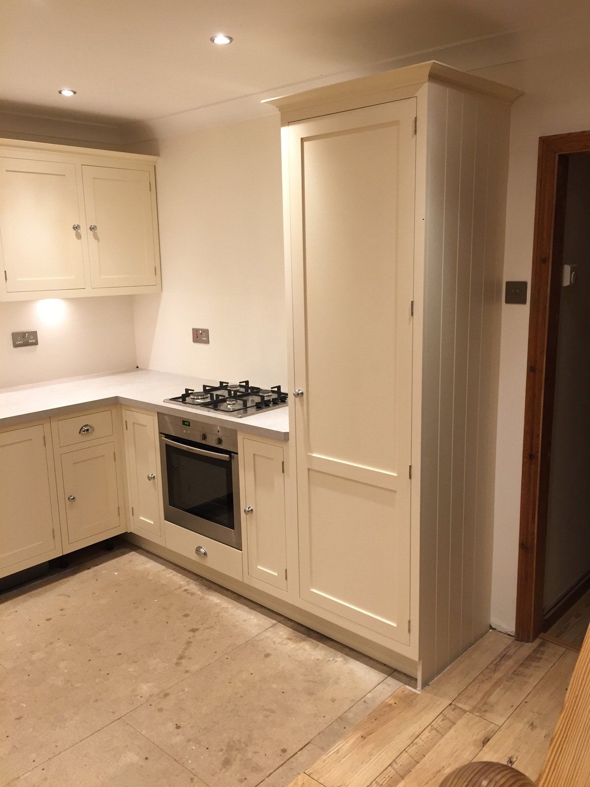 A kitchen with white cabinets , a stove top oven , and a refrigerator.