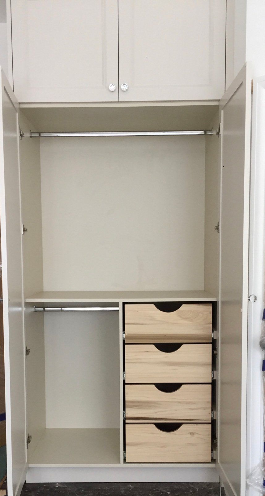 A white wardrobe with wooden drawers and shelves.
