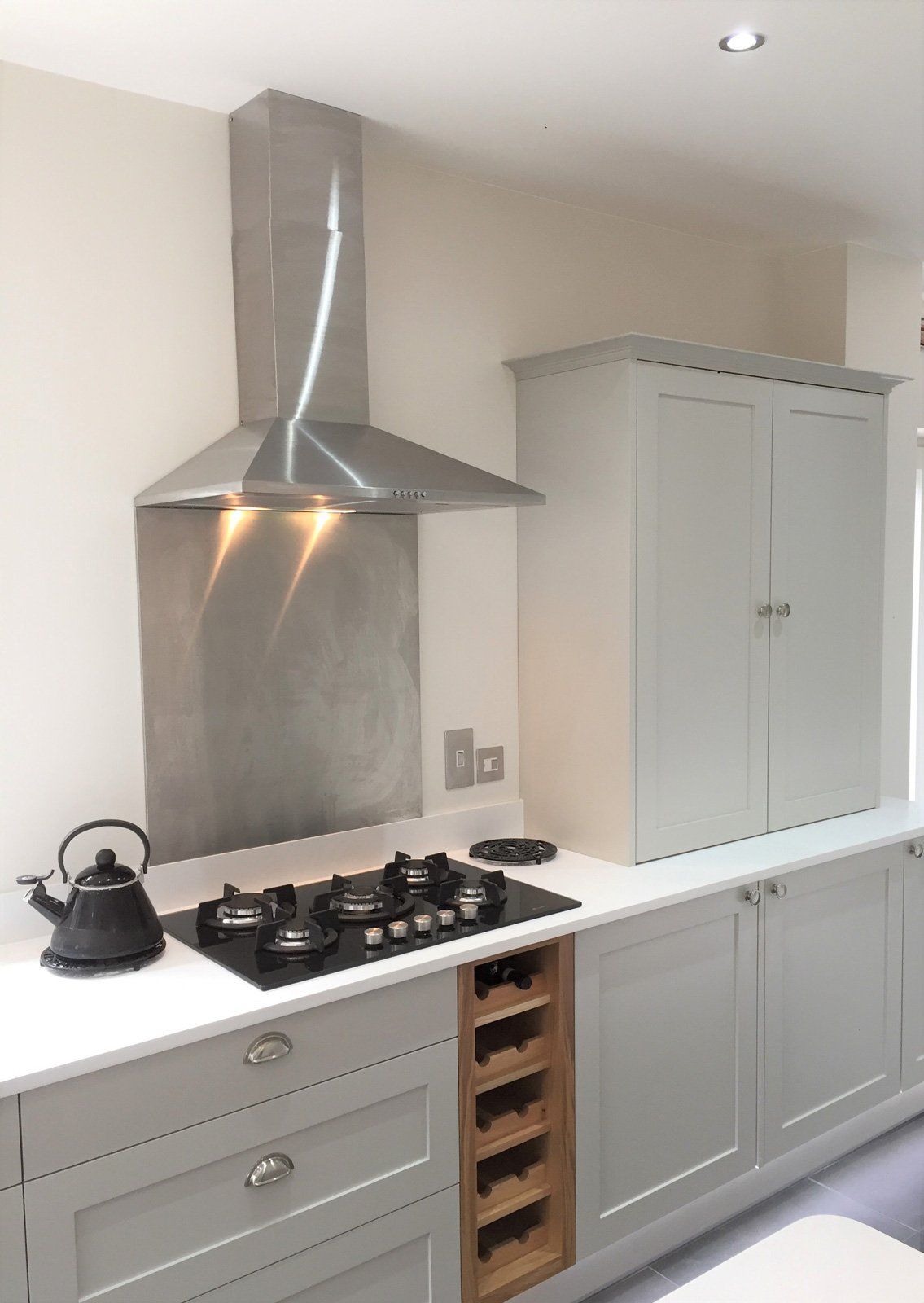 A kitchen with a stove top oven and a stainless steel hood