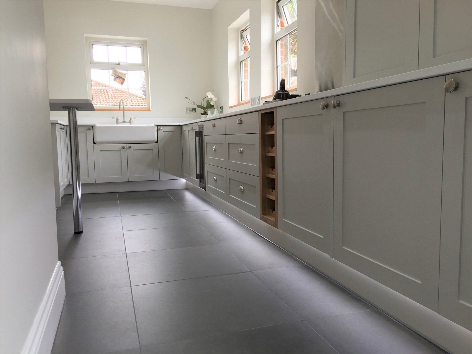 A kitchen with a lot of cabinets and a tiled floor.