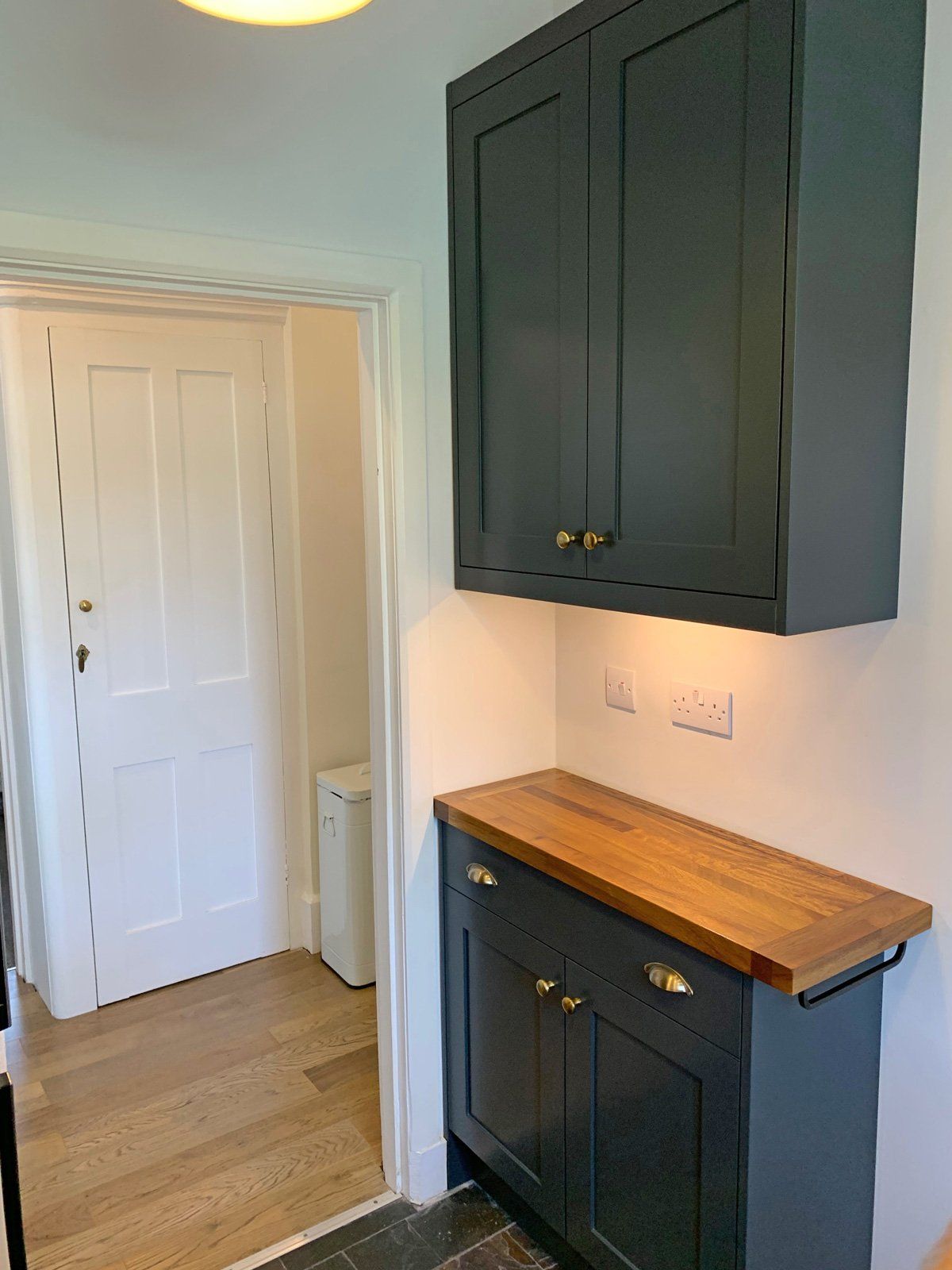 A kitchen with black cabinets and a wooden counter top.