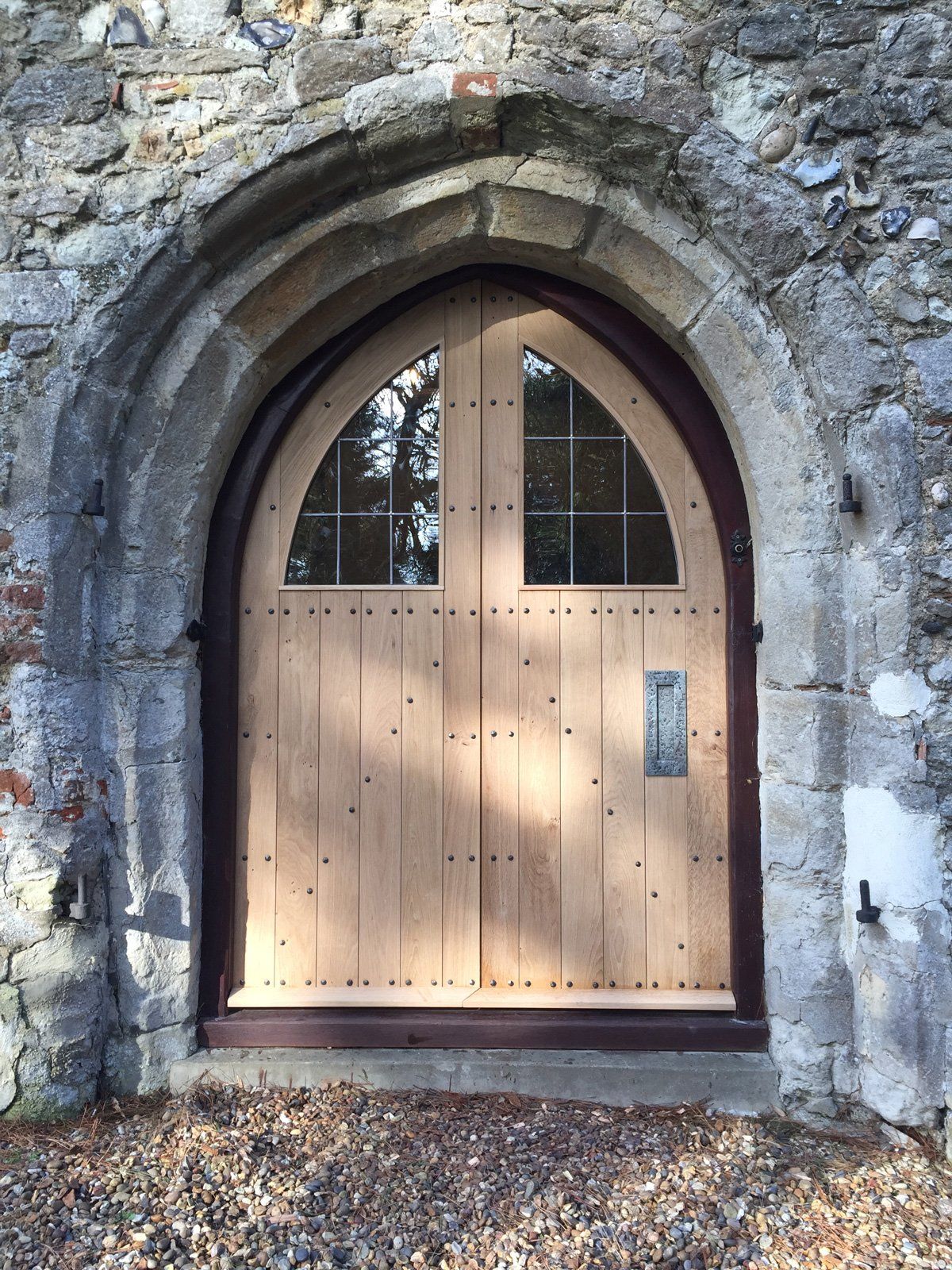 A wooden door is surrounded by a stone archway.