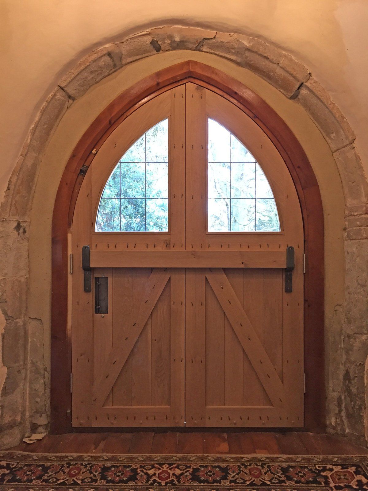 A wooden door with a stone arch around it