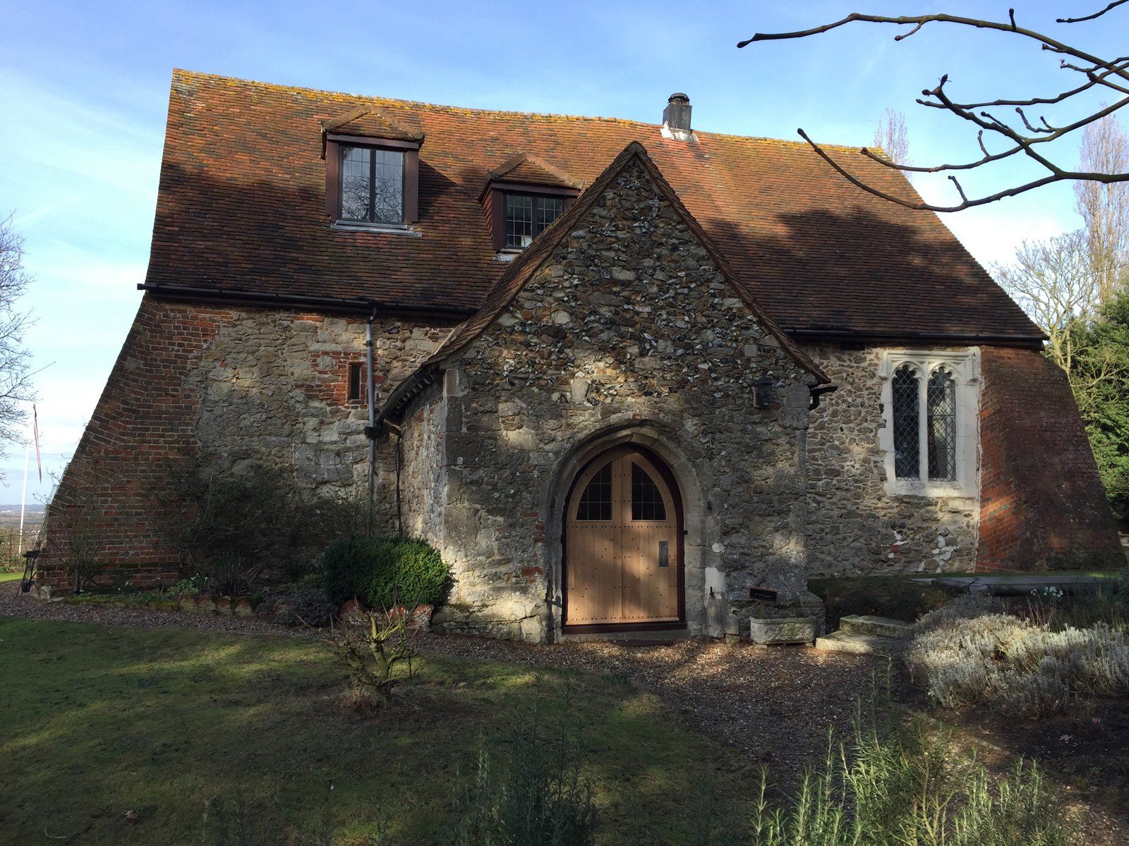 A large stone house with a brick roof and a wooden door.