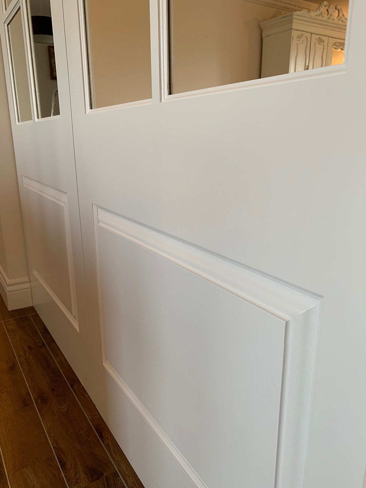 A white wall with a wooden floor in a room