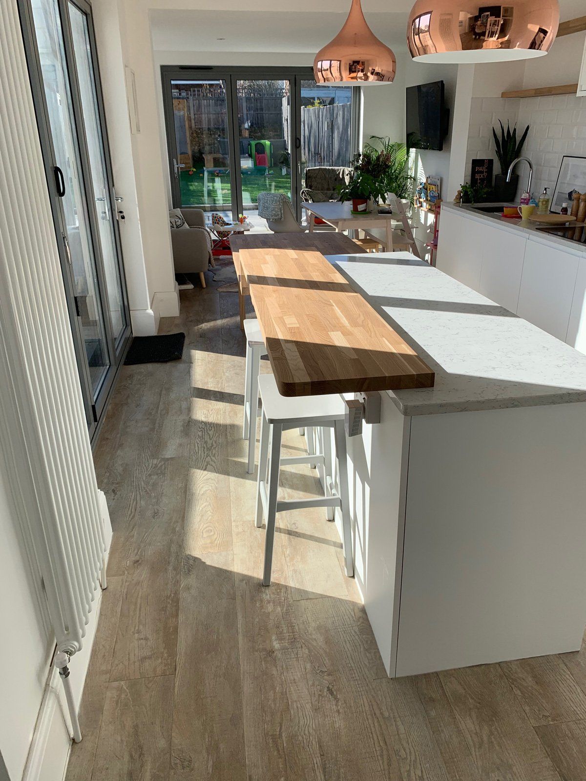 A kitchen with a long wooden table and stools.