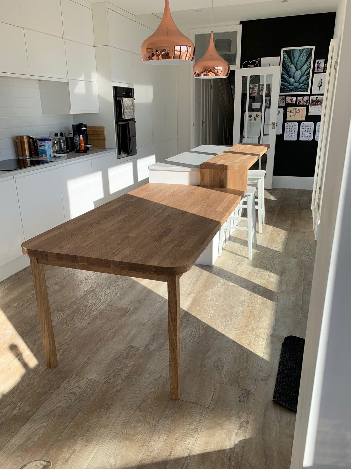 A kitchen with a wooden table and stools