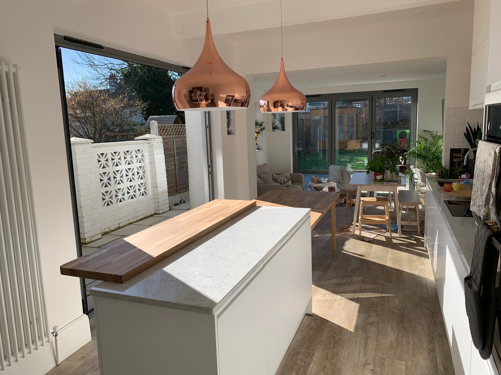 A kitchen with a large island and copper pendant lights.