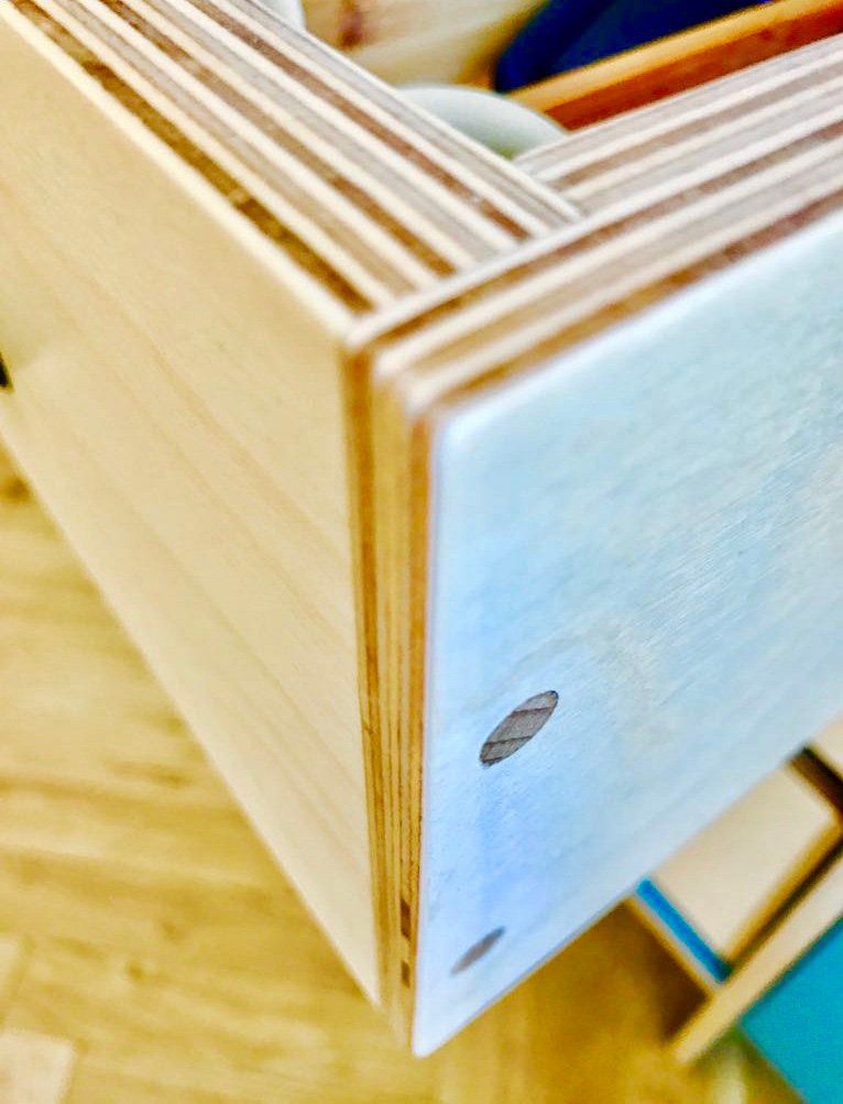 A close up of a wooden drawer with a blue top