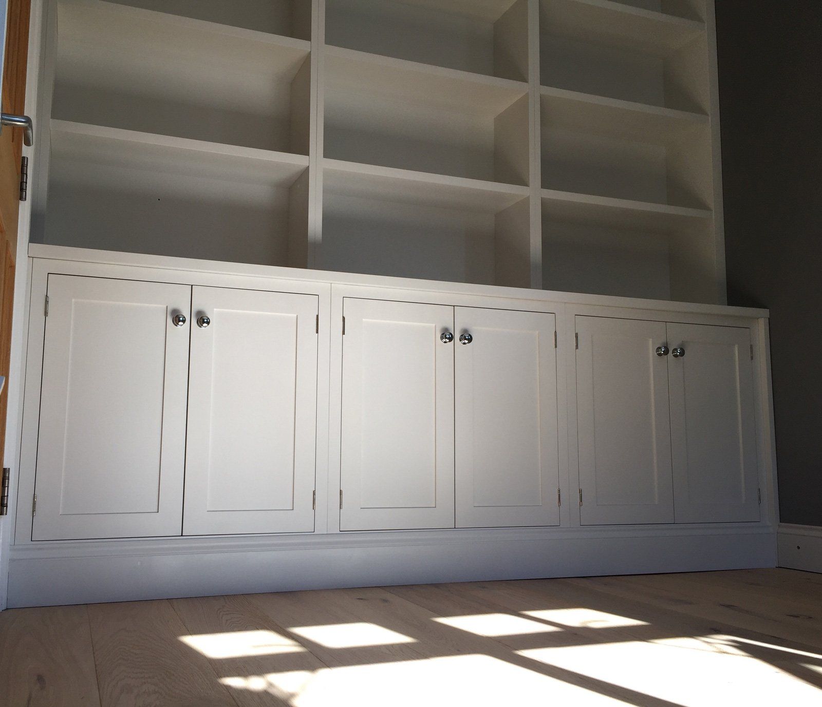 A room with lots of white cabinets and shelves