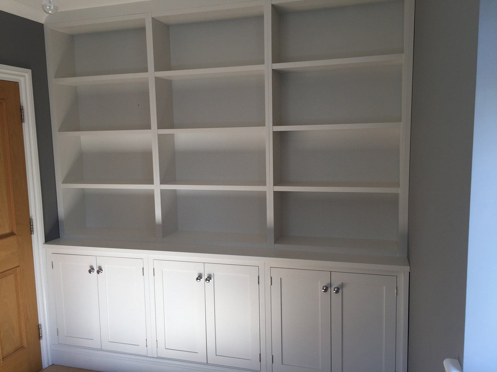 A room with a bookshelf and cabinets in it