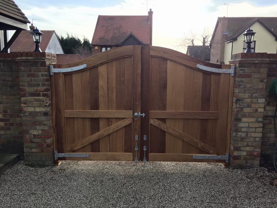 A wooden gate is sitting in front of a brick wall.