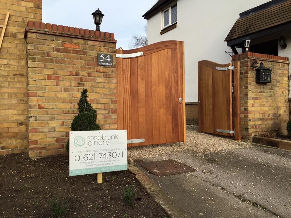 A wooden gate with a sign in front of it