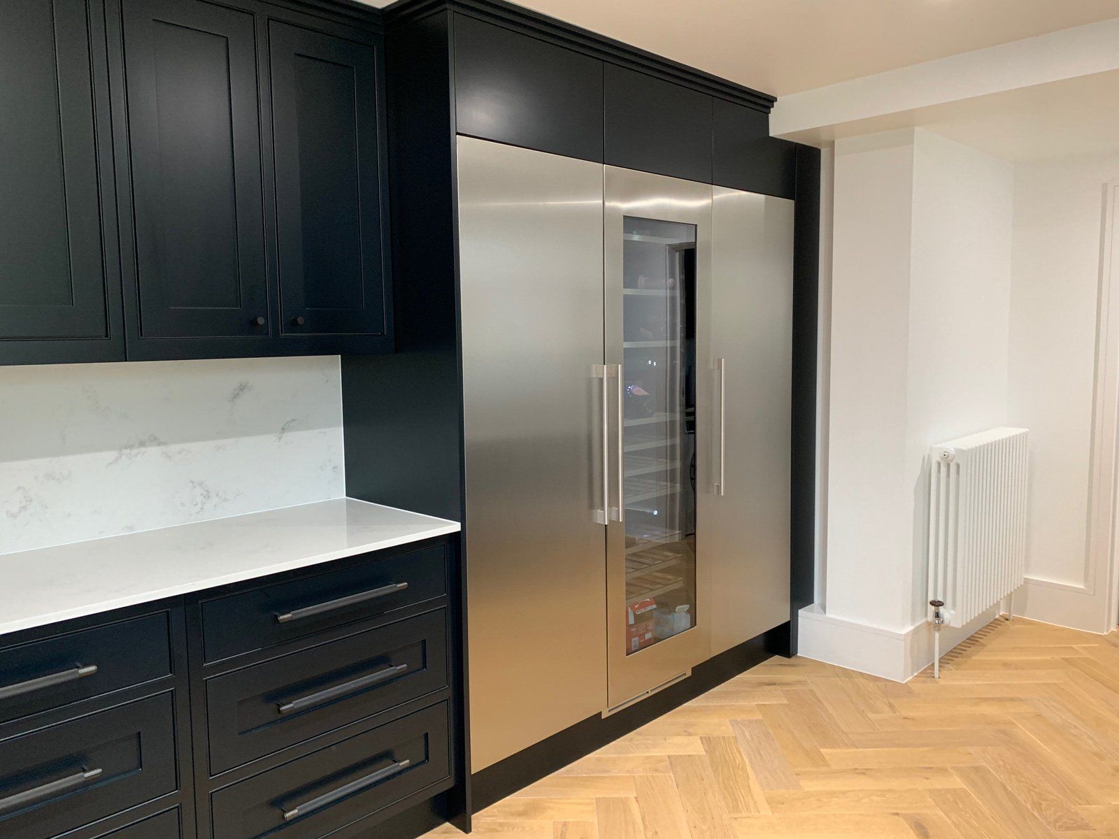 A kitchen with black cabinets and stainless steel appliances.