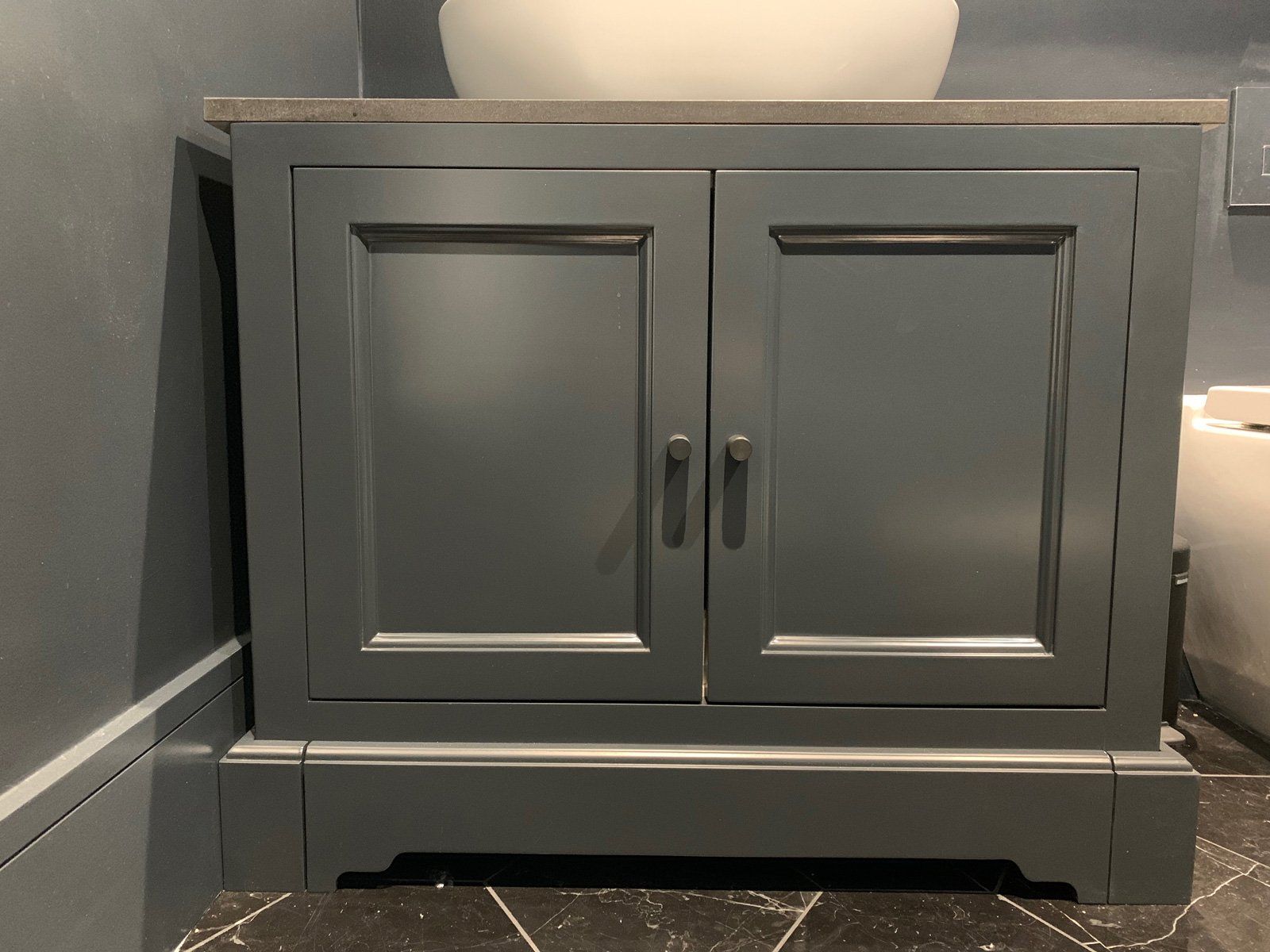 A bathroom vanity with a sink on top of it.