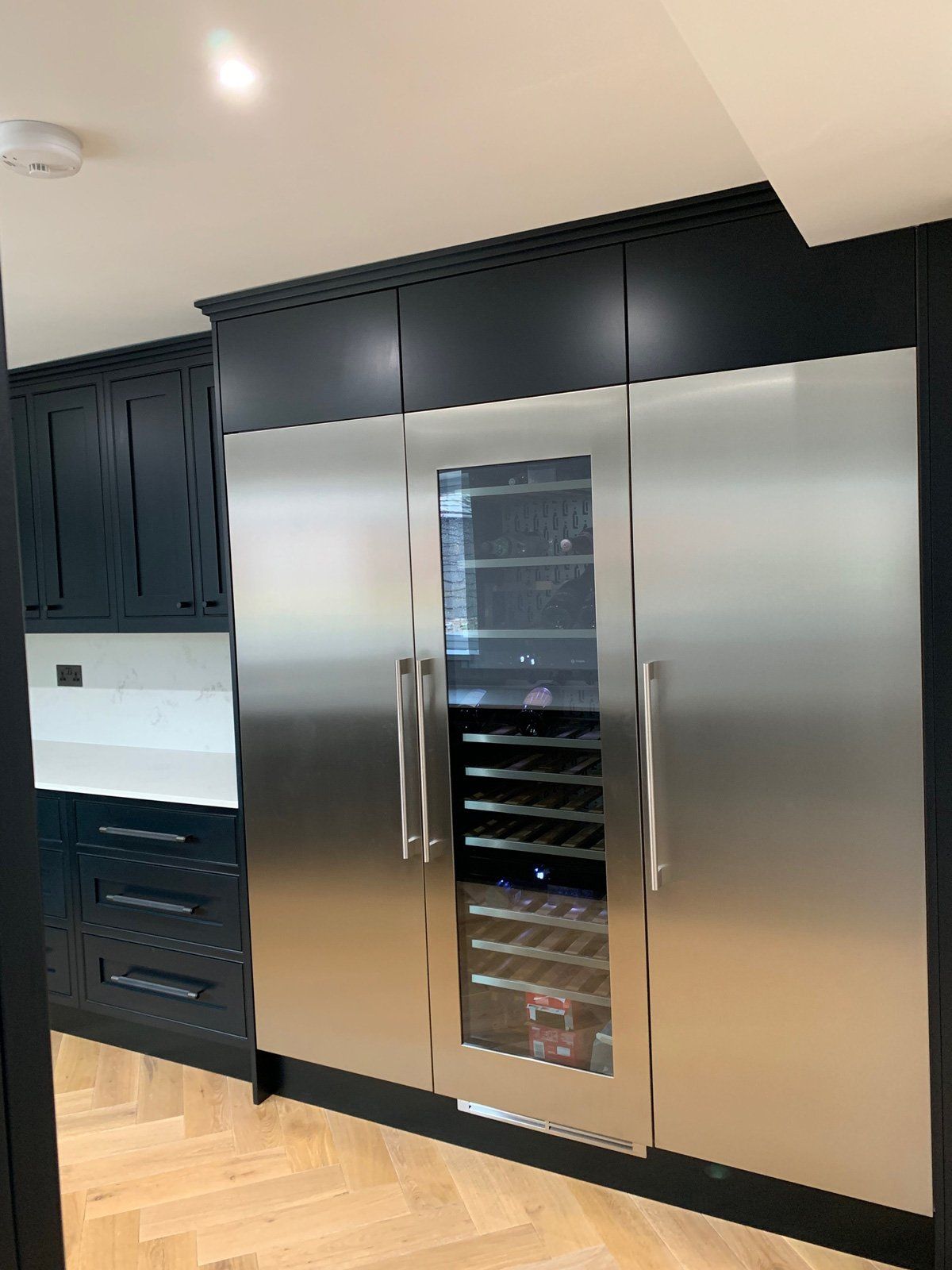 A kitchen with stainless steel cabinets and a wine cooler.