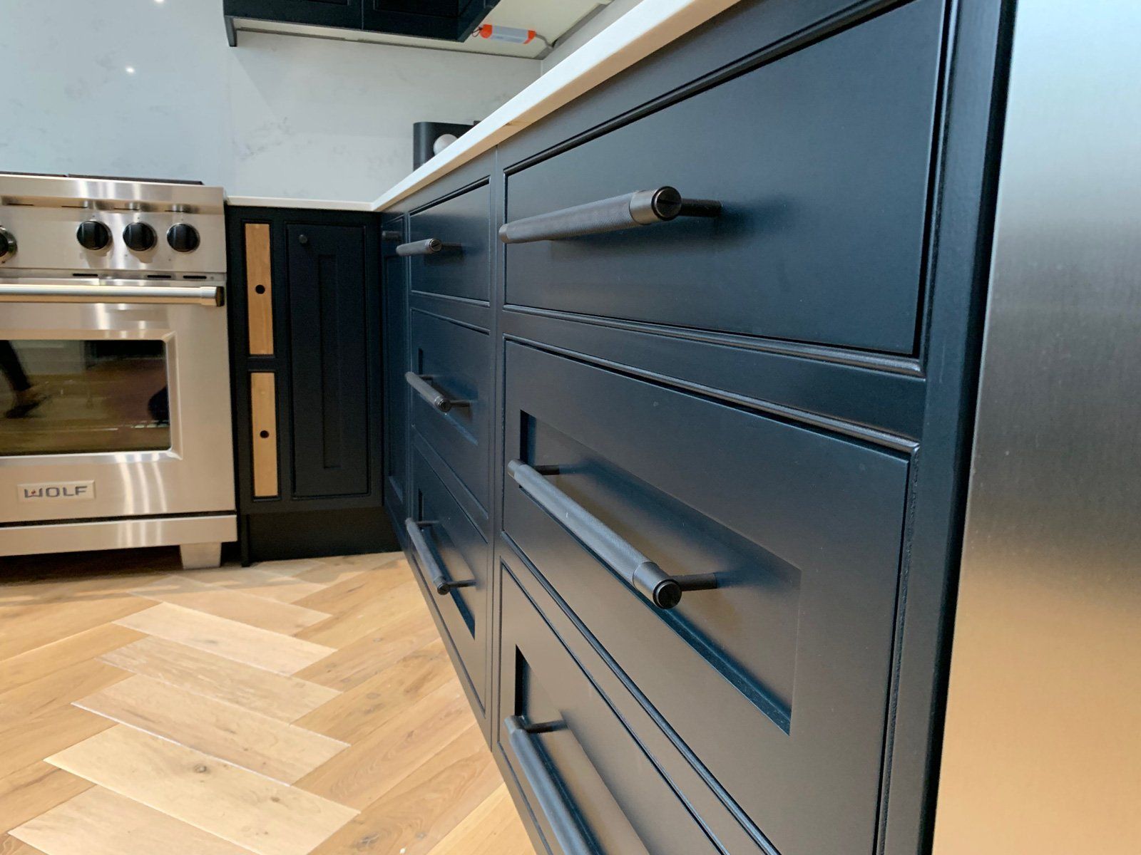 A kitchen with blue cabinets and stainless steel appliances.