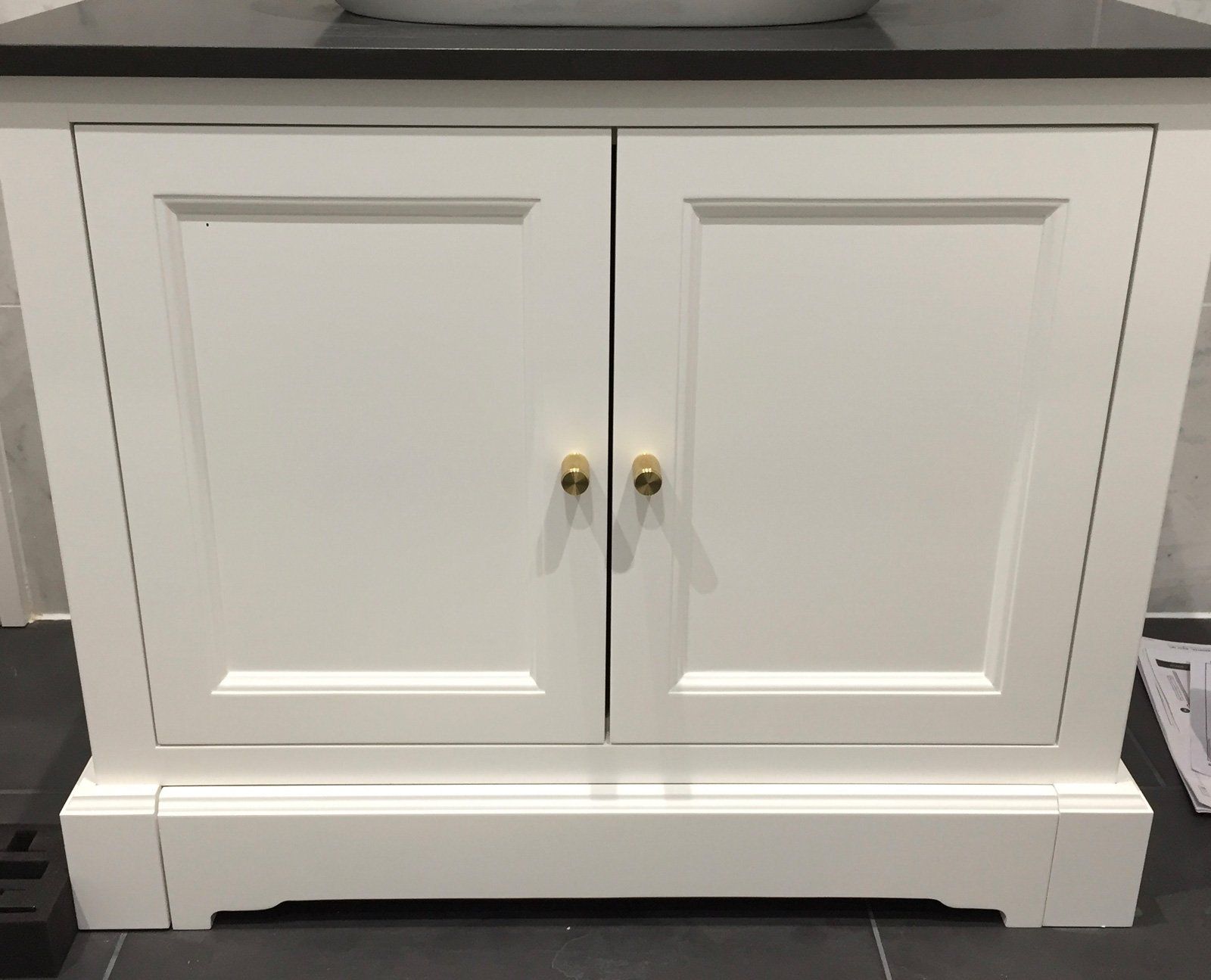 A bathroom vanity with two doors and a sink underneath it.