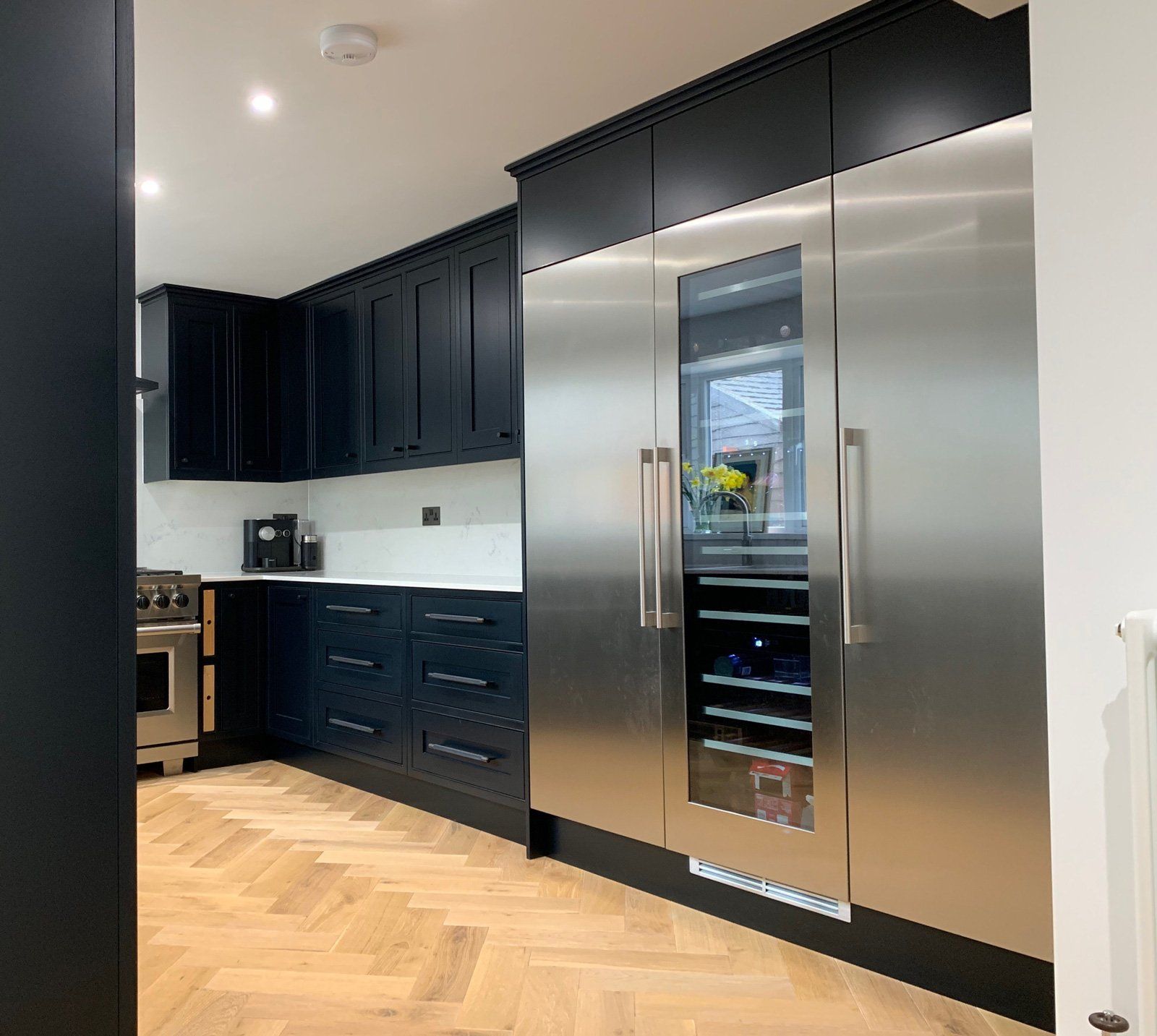 A kitchen with black cabinets and stainless steel appliances