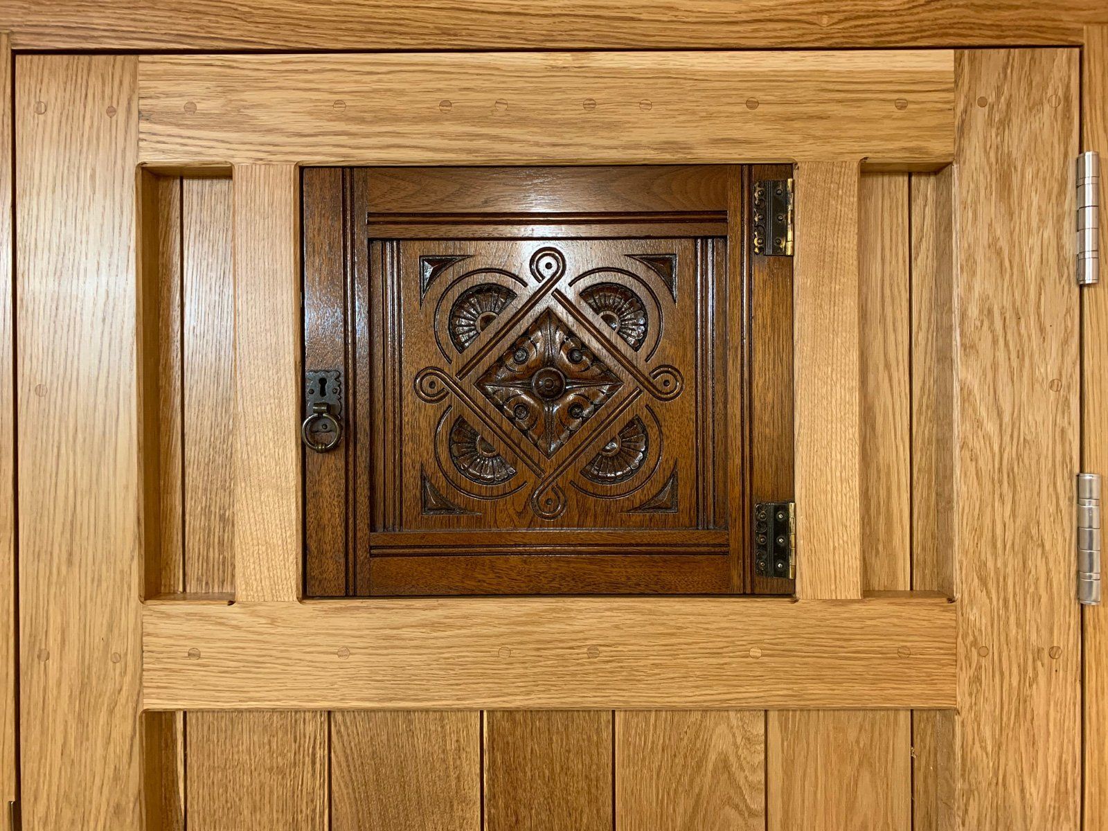 A close up of a wooden door with a window in it.