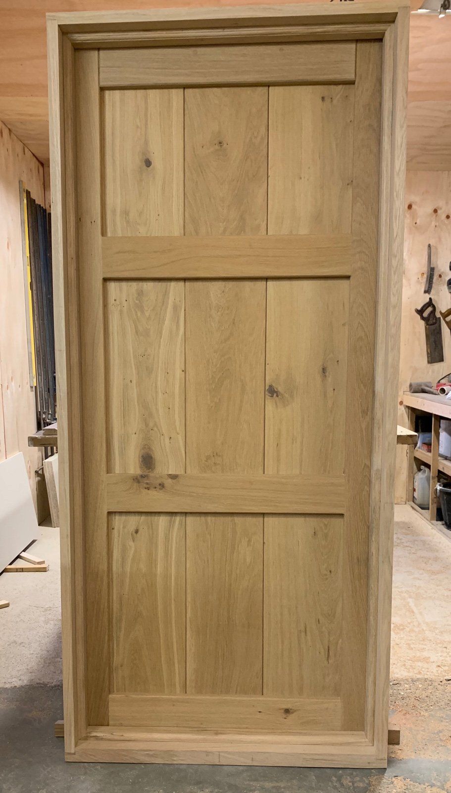 A wooden door is sitting in a woodworking shop.