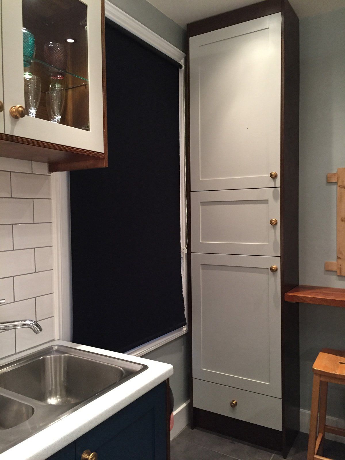 A kitchen with a sink and a tall cabinet