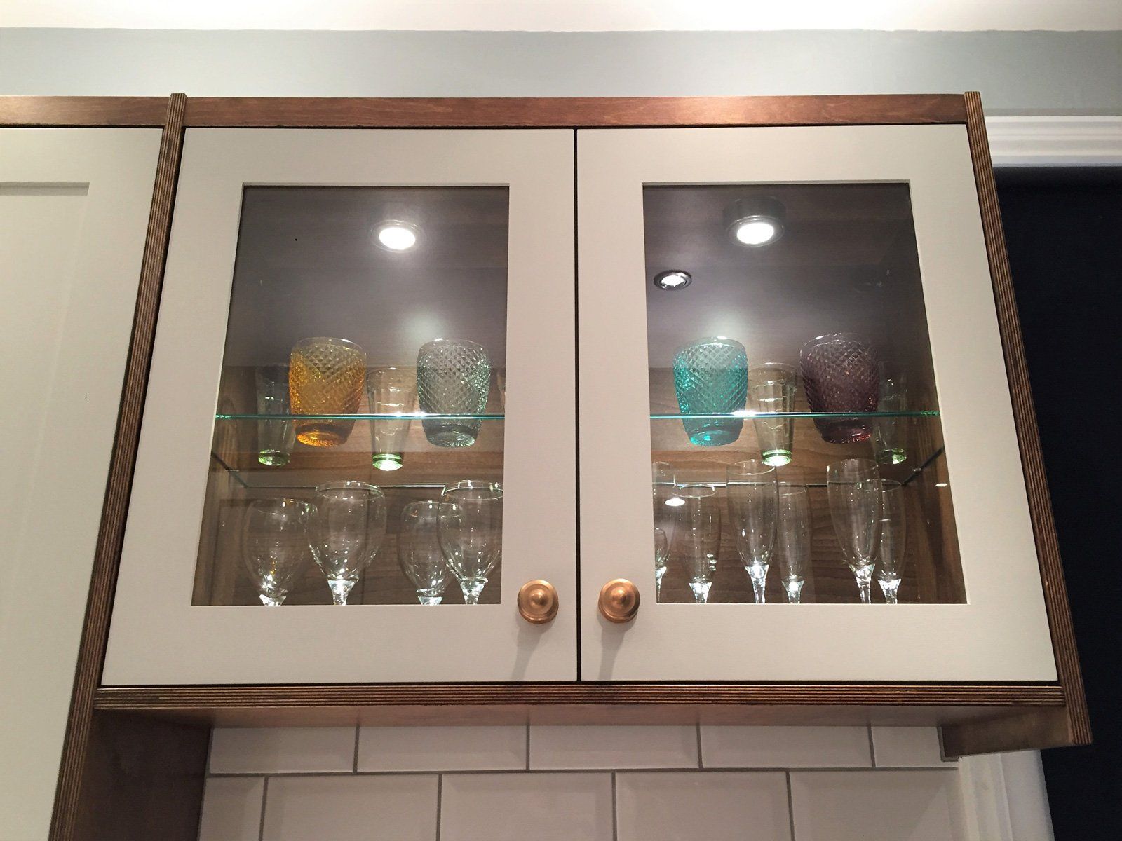 A display of wine glasses in a glass cabinet