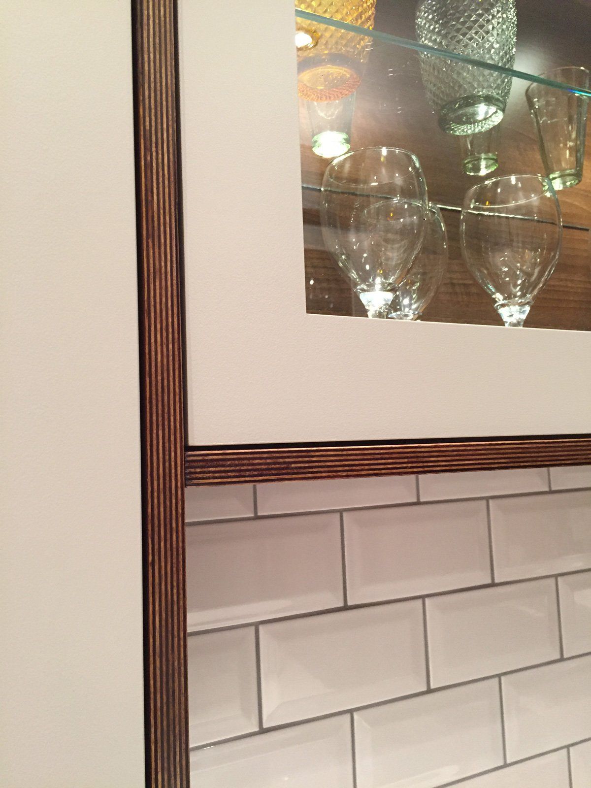 A glass shelf with wine glasses inside of it