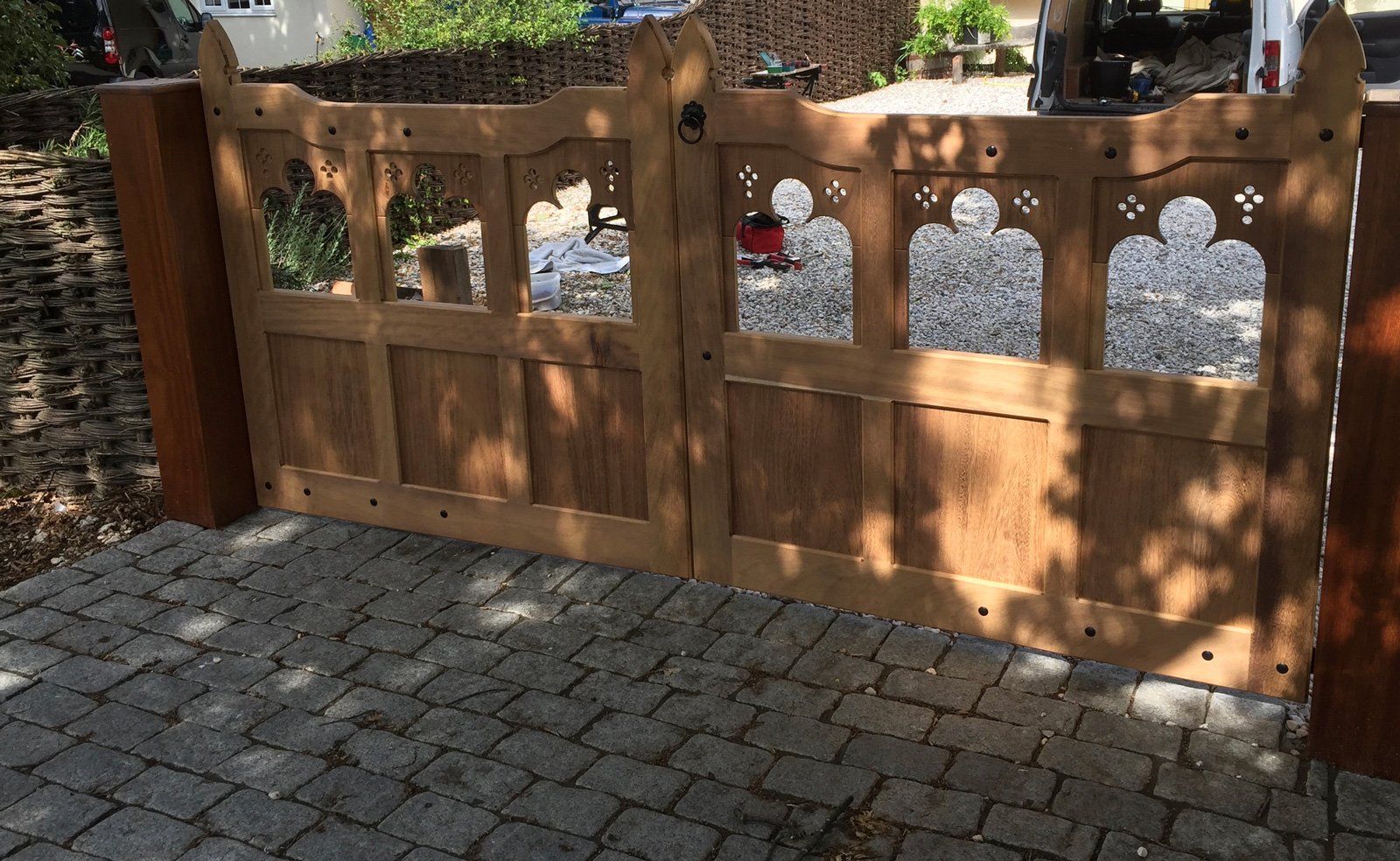 A wooden gate is sitting on top of a brick driveway.