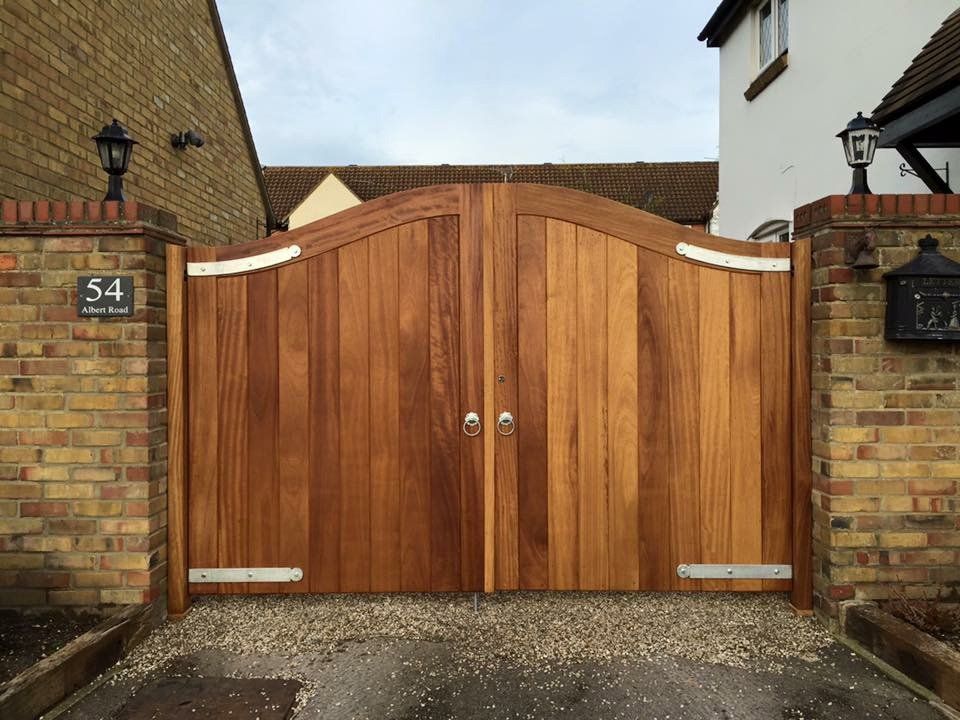 A wooden gate is sitting in front of a brick wall.