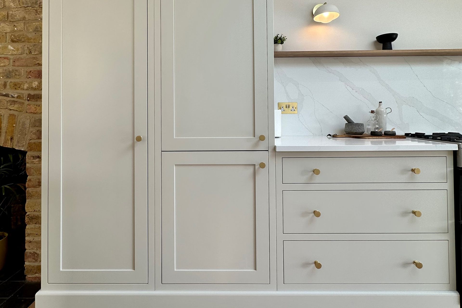 A kitchen with white cabinets and drawers and a stove top oven.