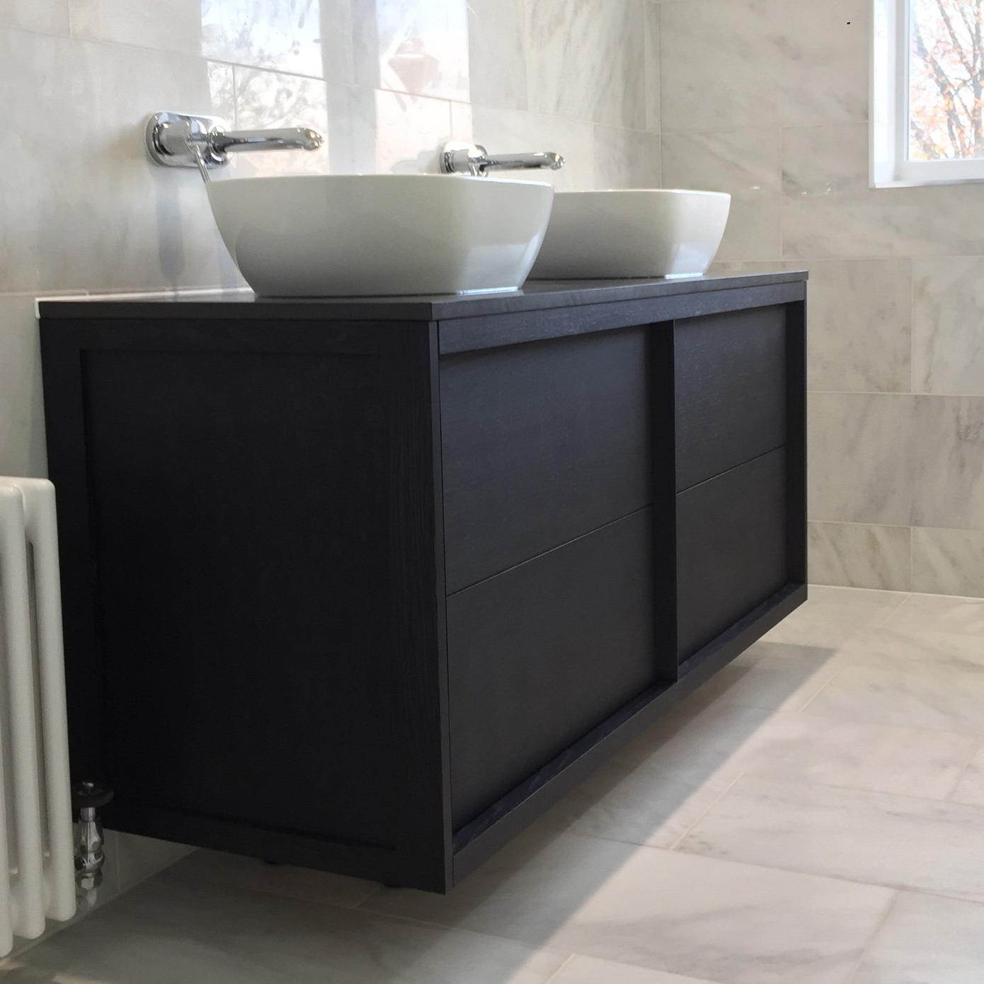 A bathroom with two sinks and a radiator