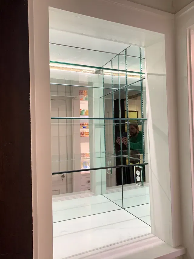 A man is standing in front of a mirror in a room.