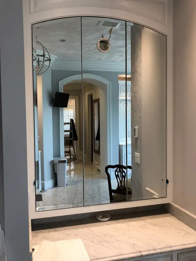 A bathroom vanity with a large mirror on the wall.