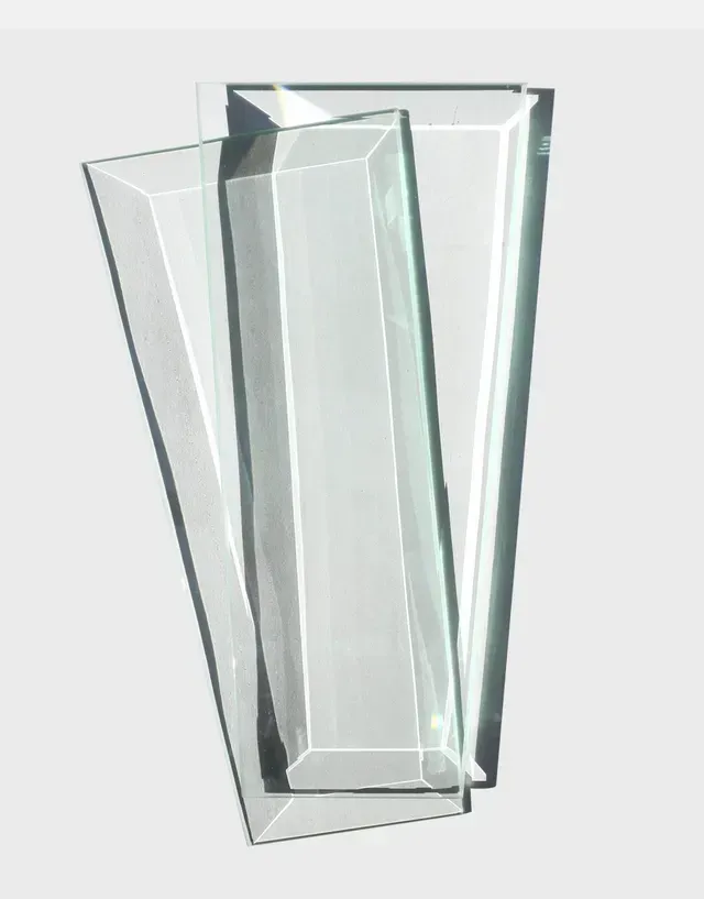 Two clear glass blocks are stacked on top of each other on a white surface.