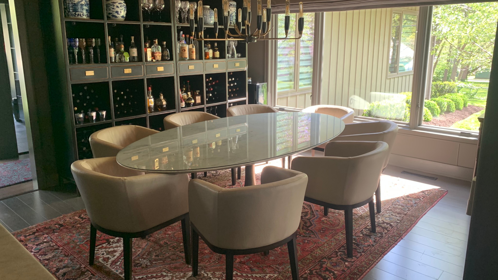 A dining room with a large table and chairs and a rug.
