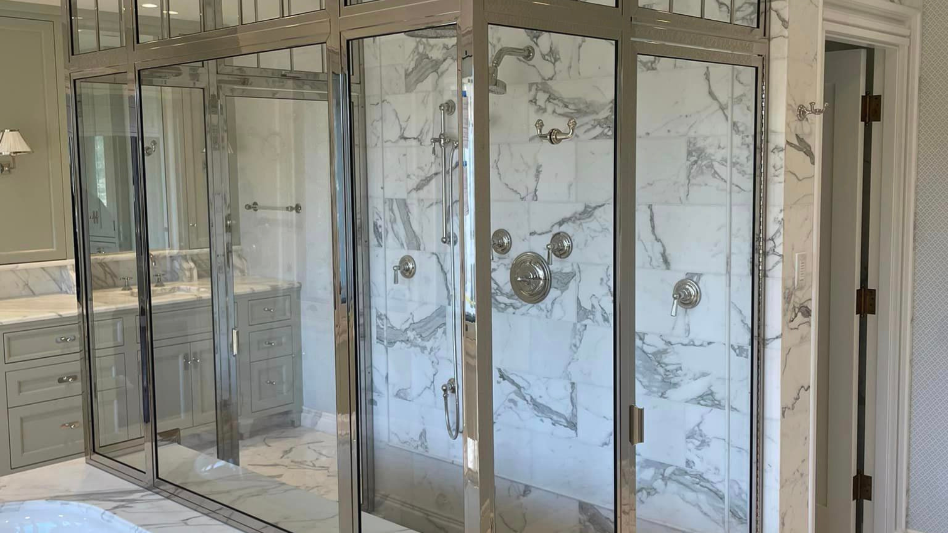 A bathroom with a walk in shower and marble tiles.