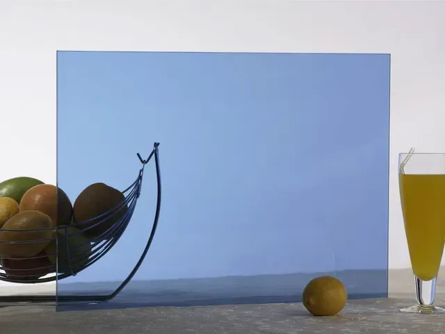 A bowl of fruit sits on a table next to a glass of orange juice.