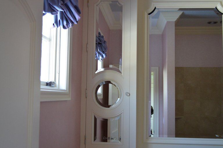 A room with a mirror on the wall and a window