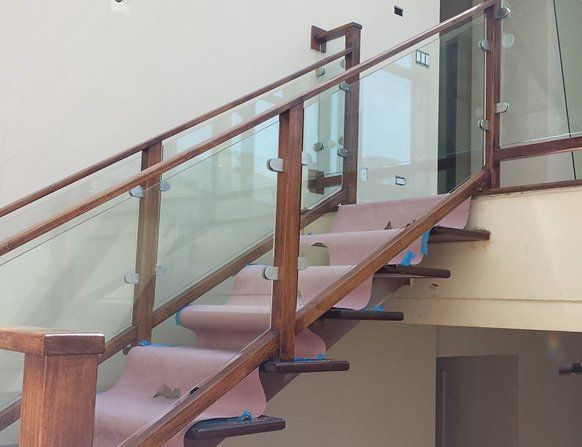A wooden staircase with a glass railing in a house