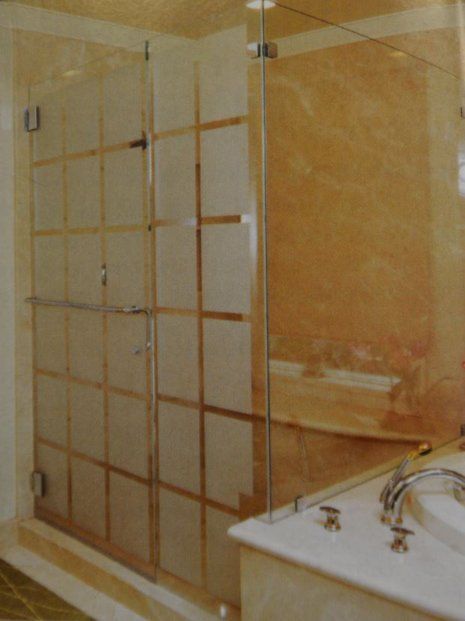 A bathroom with a glass shower door and a sink