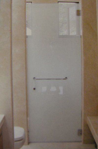 A bathroom with a toilet and a glass shower door