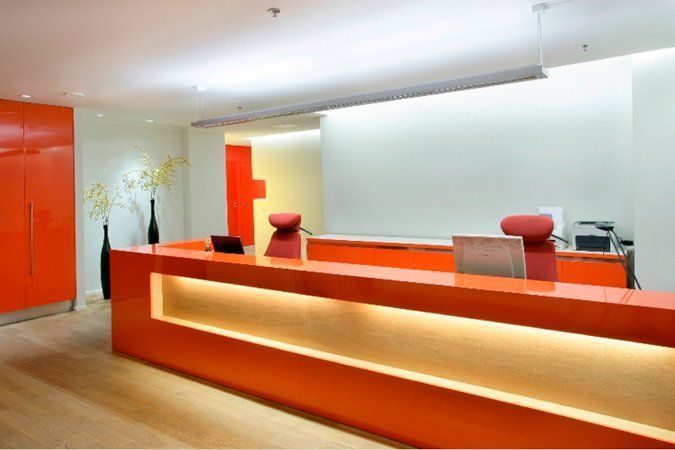 A reception area with orange counters and chairs