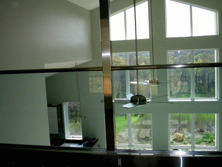 A room with a lot of windows and a stainless steel railing