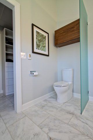 A bathroom with a toilet and a walk in shower.